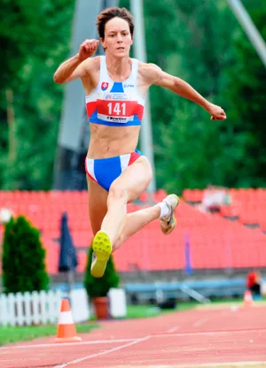Skokanka v slovenskom reprezentačnom drese počas skoku na atletickej dráhe.