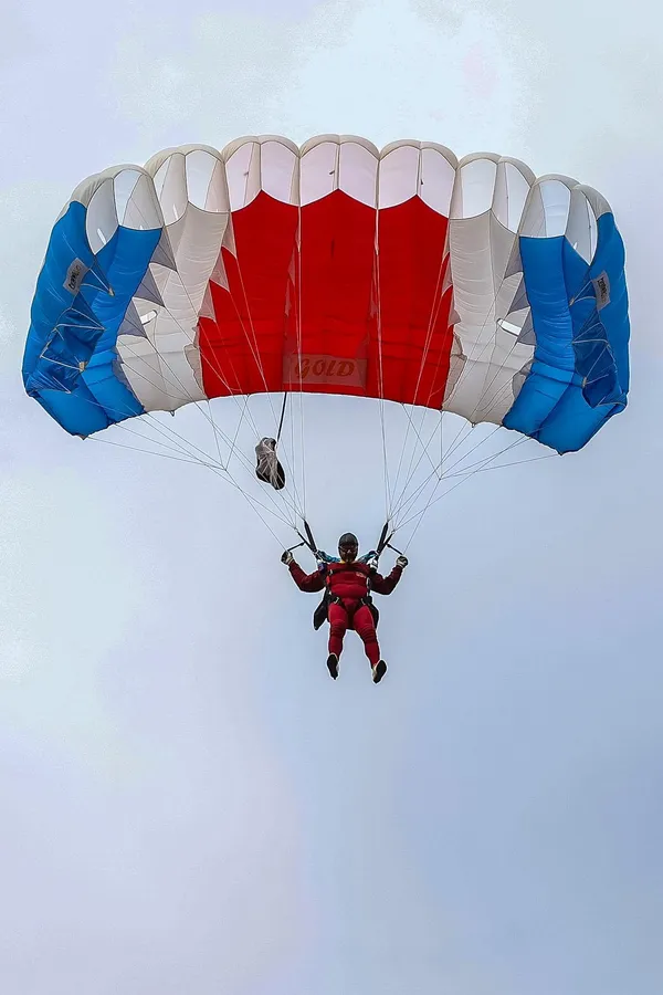 Parašutista pod padákom tesne pred pristátím