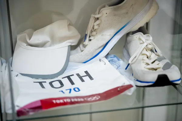 Štartové číslo Mateja Tótha z olympiády v Tokiu a jeho tretry vo vitríne.