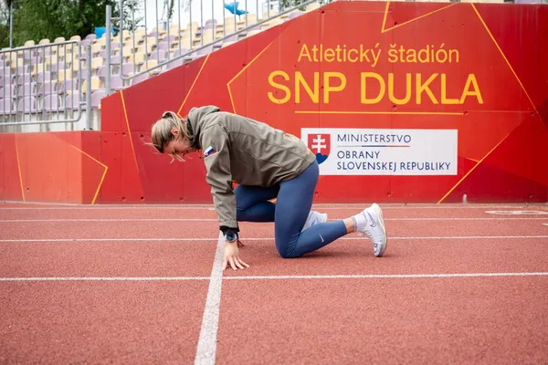 Športovkyňa na štarte pred tribúnou Atletického štadióna SNP DUKLA